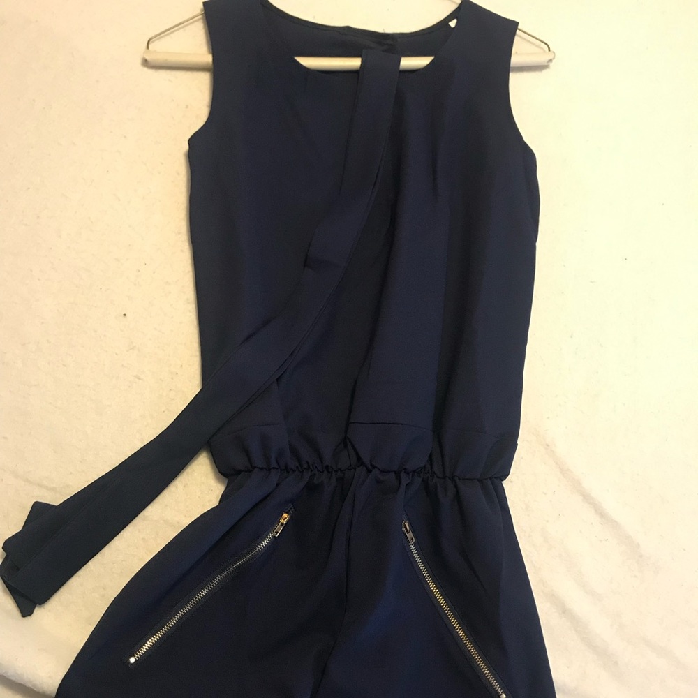 Navy blue Romper with gold zipper pockets. Tank top style and shorts and belt